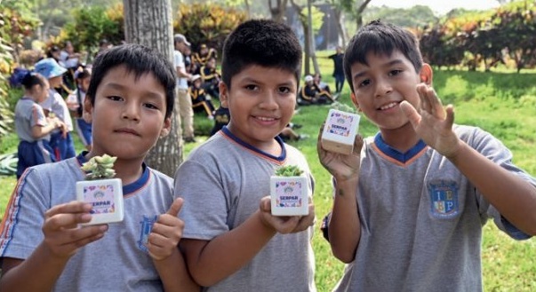Niños con plantones entregados por el programa